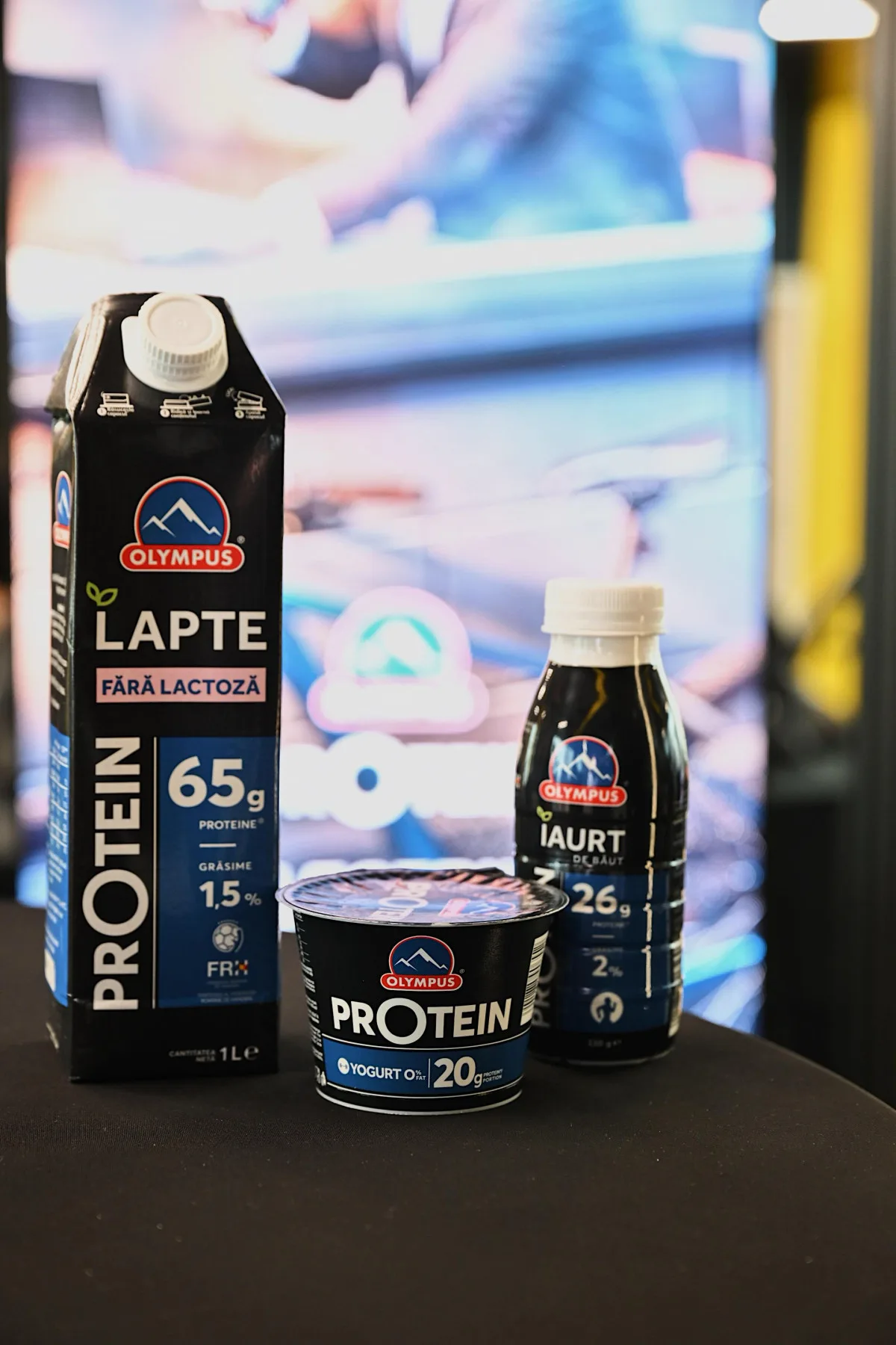 Produse lactate Olympus, inclusiv lapte și iaurt, pe un fundal modern.