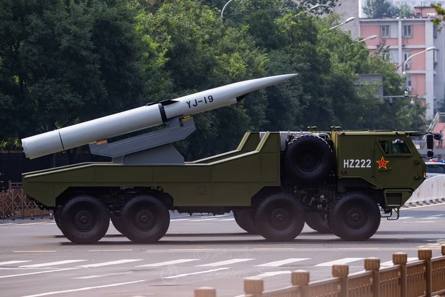 Vehicul militar chinezesc transportând un sistem de rachete pe o stradă urbană.