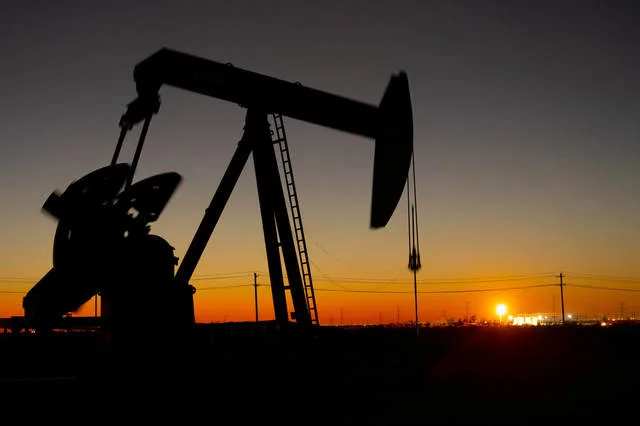 Pompa de petrol în lumina apusului, simbol al pieței energetice.