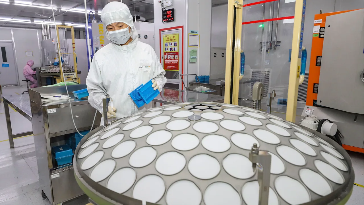 Un angajat în echipament de protecție într-o fabrică de semiconductori.