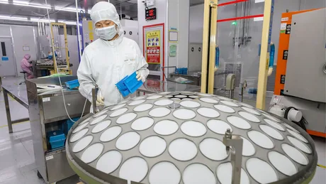 Un angajat în echipament de protecție într-o fabrică de semiconductori.