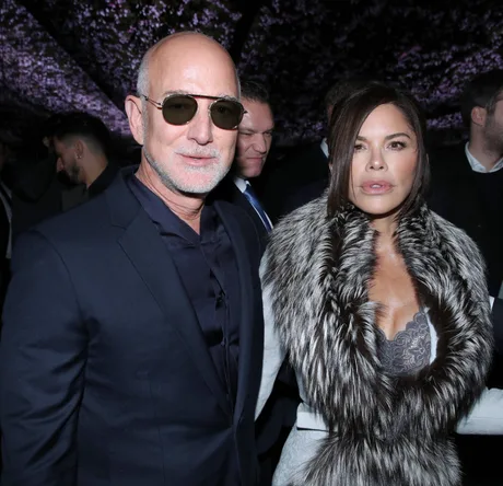 Jeff Bezos și o persoană la un eveniment, discutând despre schimbări în media.