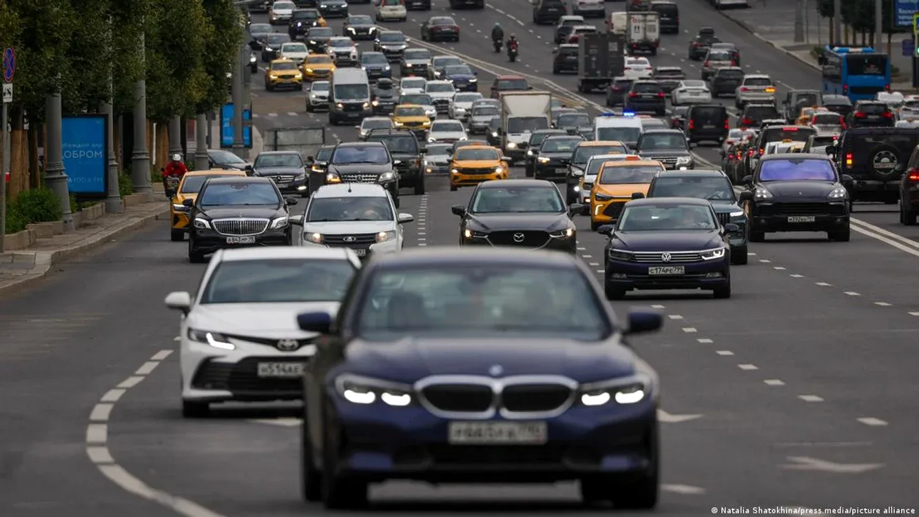 Trafic intens pe o stradă din Rusia, cu mașini diverse circulând.