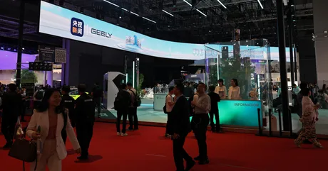 Salonul auto de la Beijing cu standuri și vizitatori, evidențiind inovațiile din industria auto.