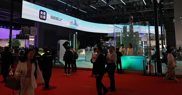 Salonul auto de la Beijing cu standuri și vizitatori, evidențiind inovațiile din industria auto.