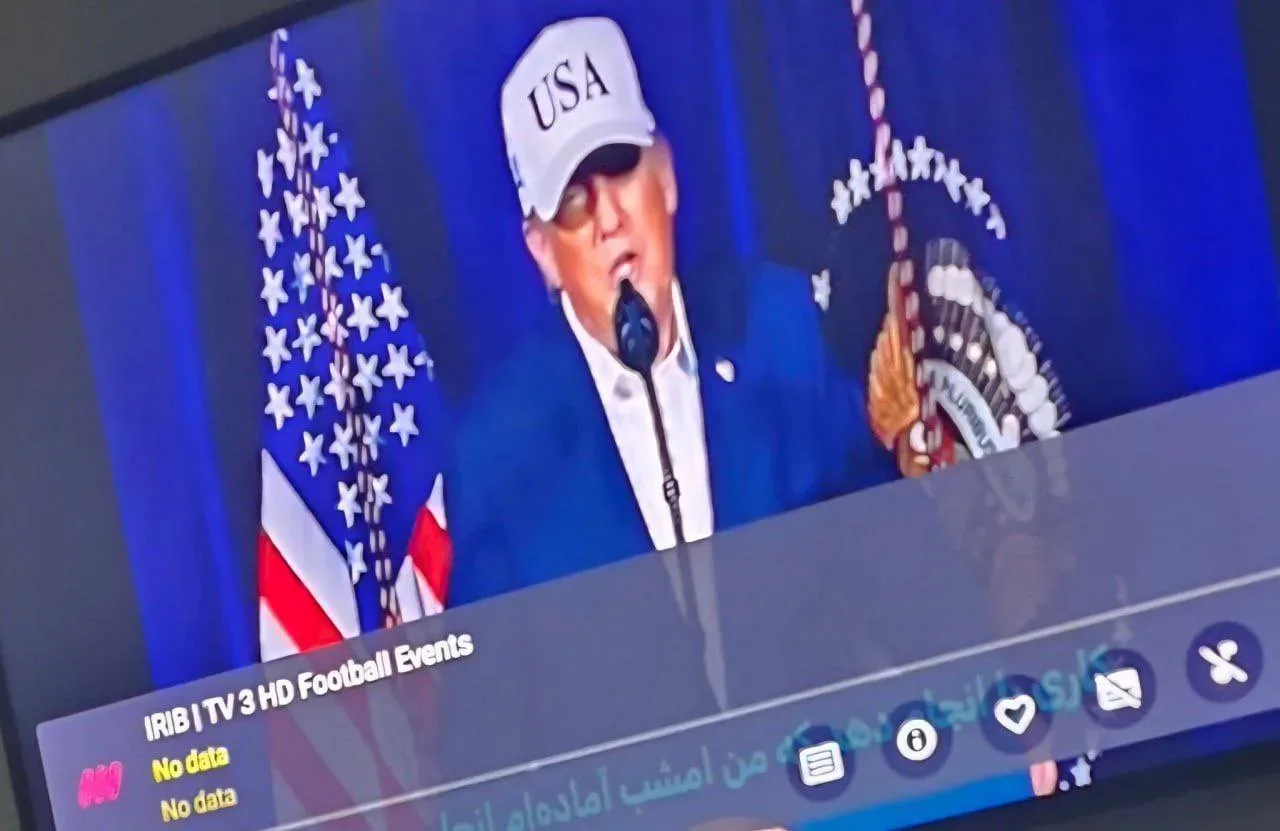 Un discurs ironic al lui Trump, cu steaguri americane în fundal.