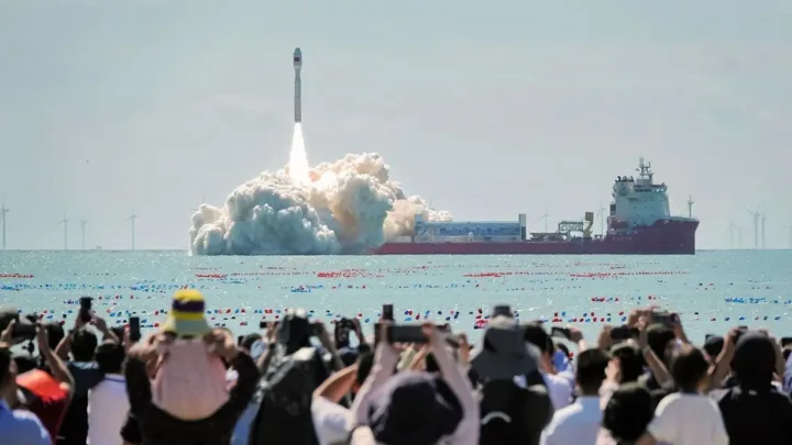 Lansare de rachetă din Marea Chinei de Sud, cu spectatori entuziasmați.