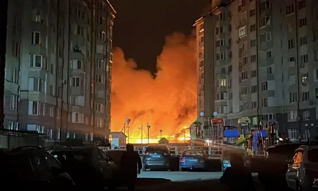 Flăcări uriașe izbucnesc între clădiri în urma atacurilor aeriene.