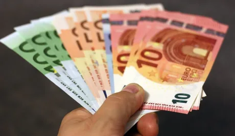 Bancnote euro în mână, simbolizând fondurile europene pentru România.