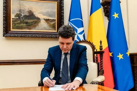 Nicușor Dan semnează documente în biroul său oficial.