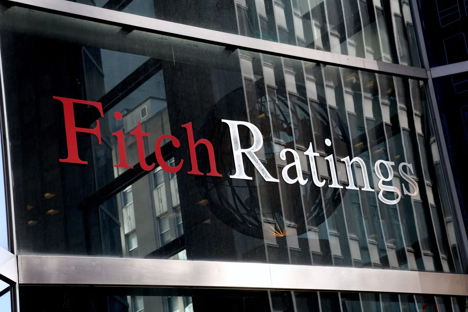 Logo-ul Fitch Ratings pe o clădire modernă din oraș.