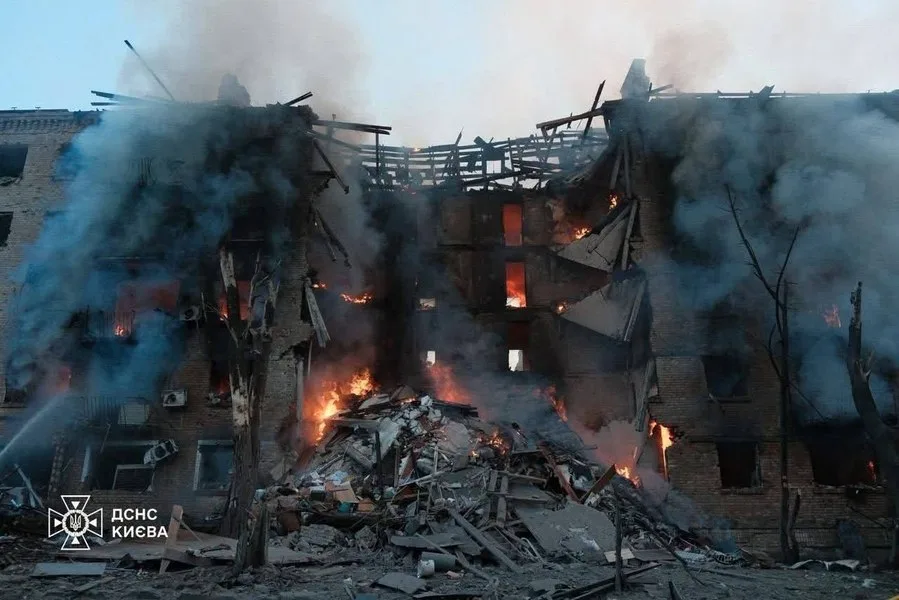 Clădire avariată în urma atacului aerian din Kiev, cu fum și ruine vizibile.