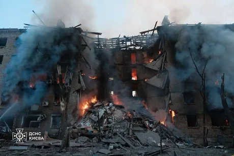 Clădire avariată în urma atacului aerian din Kiev, cu fum și ruine vizibile.