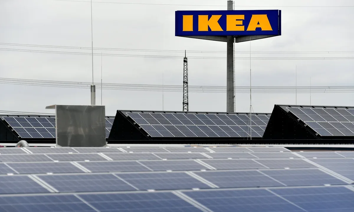 Panouri solare instalate în parc fotovoltaic, cu logo IKEA în fundal.