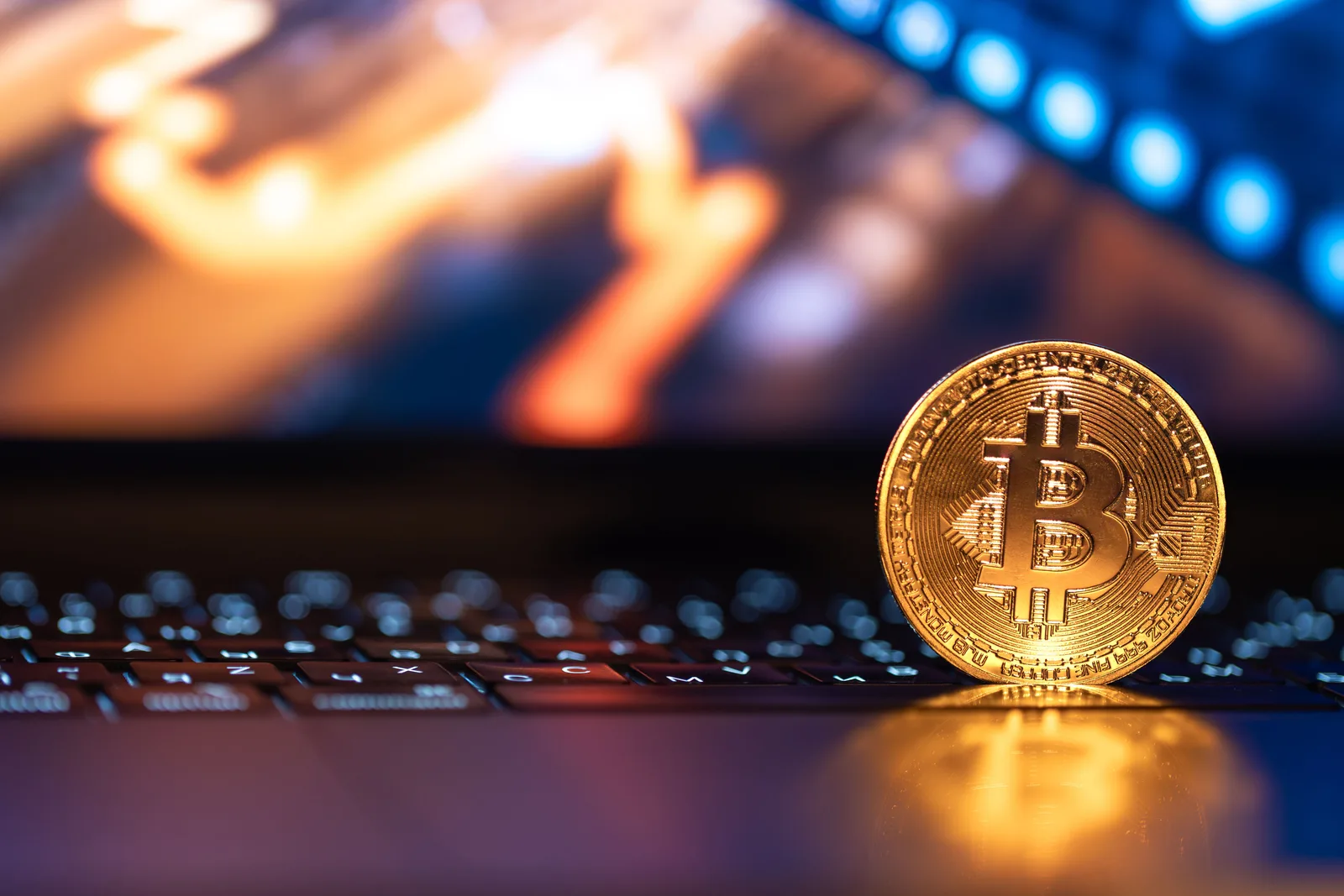 Monede digitale pe un laptop, simbolizând viitorul finanțelor globale.