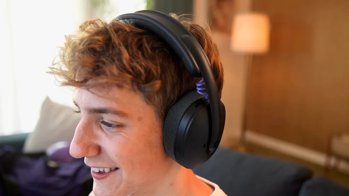 Headsetul wireless G325 LIGHTSPEED pe capul unui utilizator zâmbitor.