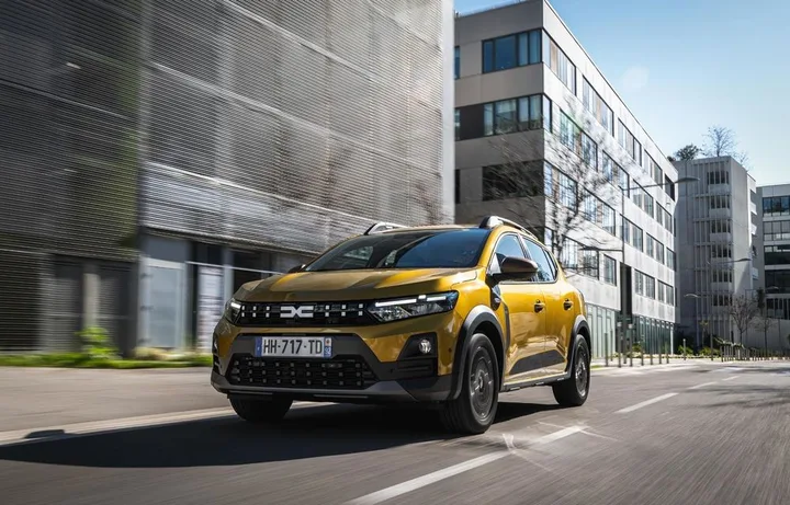 Dacia Sandero circulând pe o stradă modernă, evidențiind designul său contemporan.