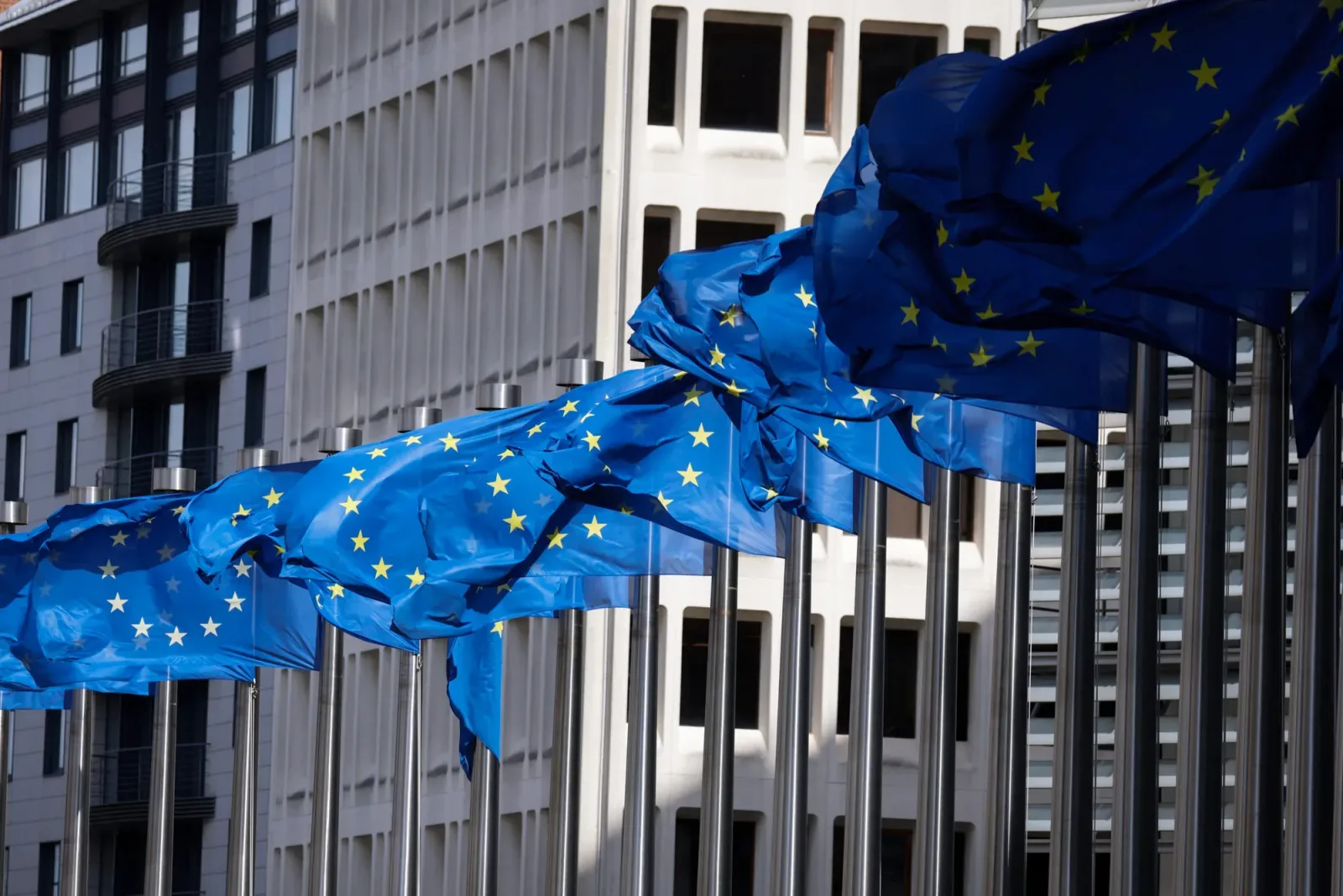 Clădirea Comisiei Europene cu steaguri ale Uniunii Europene.