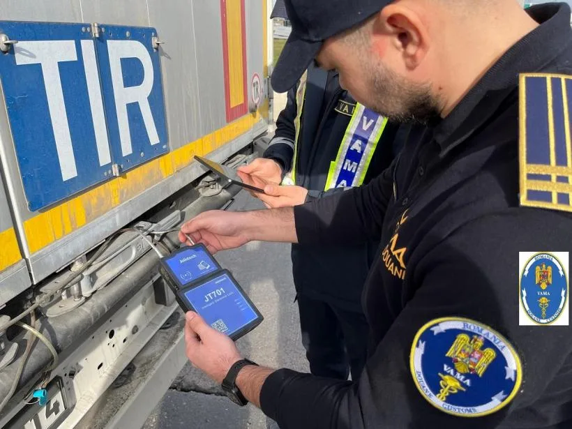 Un agent vamal verifică documentele unui camion în trafic.