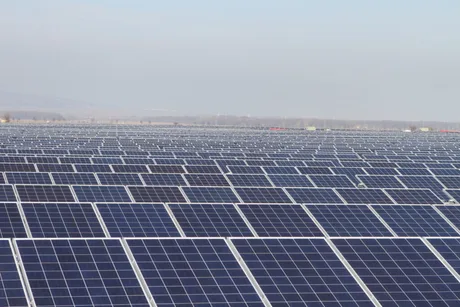 Panouri solare amplasate pe un câmp vast, simbolizând energia regenerabilă.