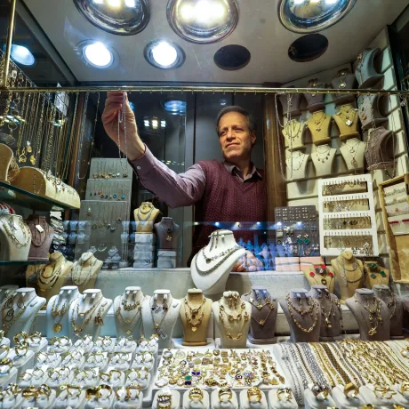 Un bijutier aranjează bijuterii din aur într-un magazin elegant.