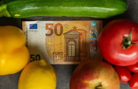 Bancnotă de 50 de euro între legume și fructe proaspete.