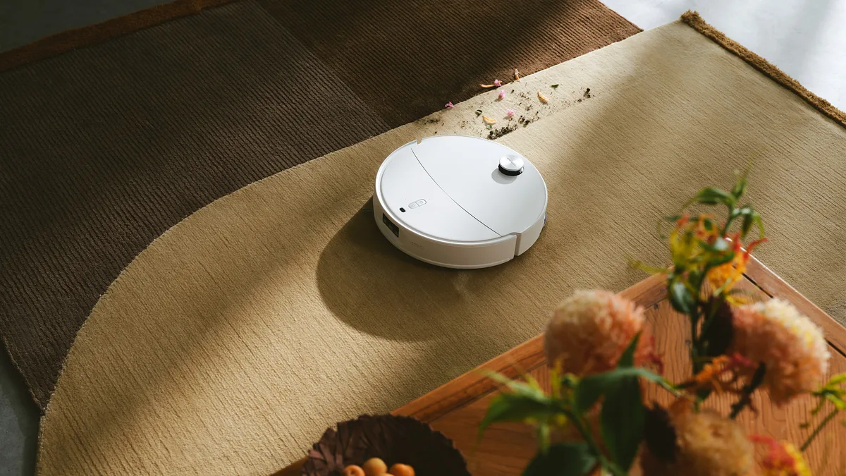 Aspirator robot pe covor, curățând eficient murdăria.