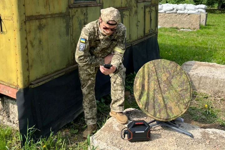 Soldat rus folosind un dispozitiv de comunicație în condiții dificile.