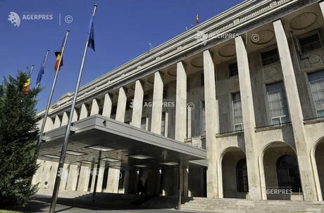 Clădirea Guvernului României, cu steaguri fluturând la intrare.