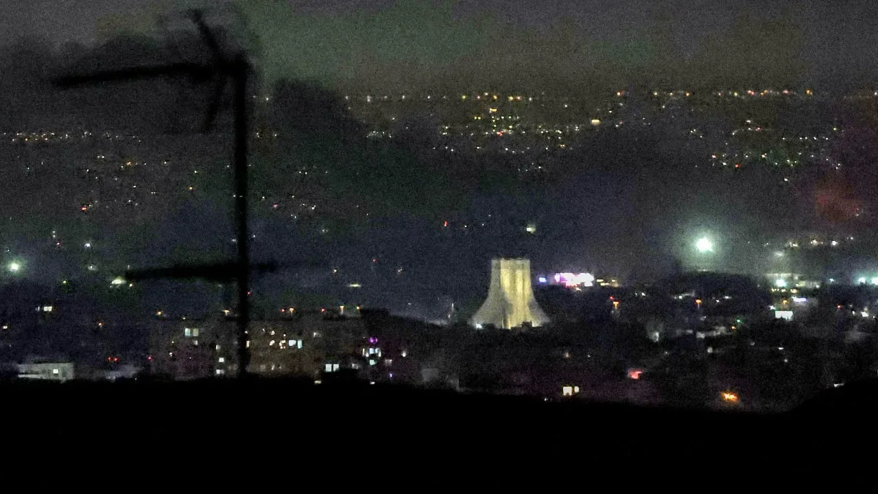 Vedere nocturnă a unui oraș cu iluminare urbană și structuri industriale.