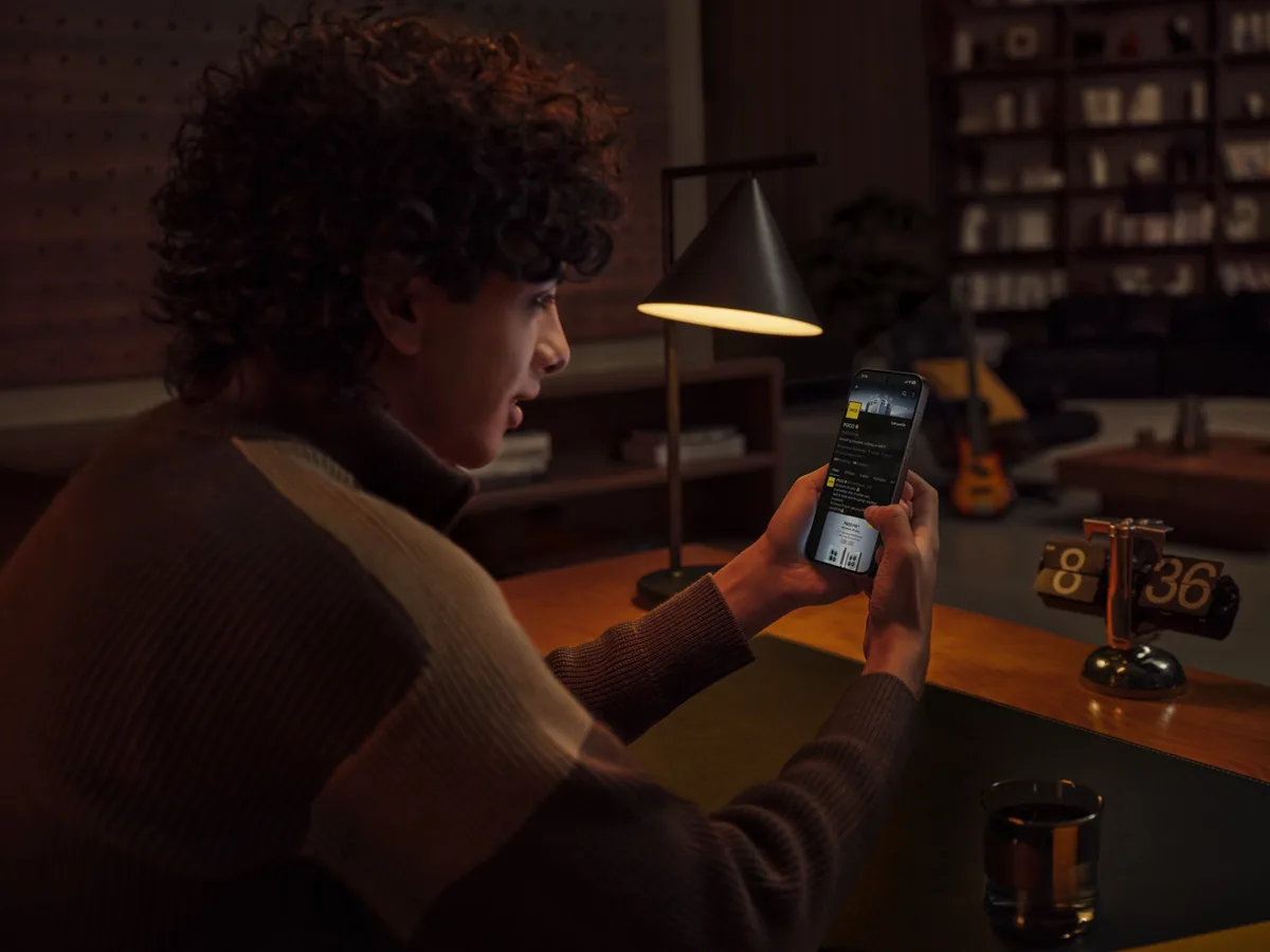 Utilizator interacționând cu smartphone-ul POCO X8 Pro într-un ambient modern.
