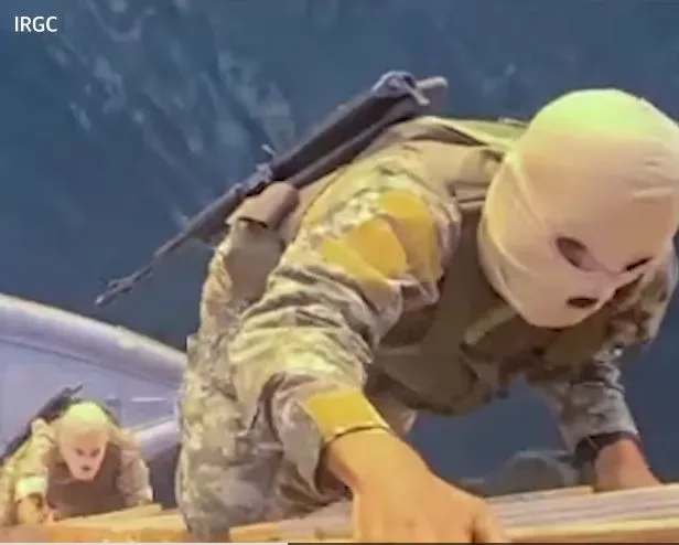 Trupe iraniene înarmate urcând pe o navă în Strâmtoarea Ormuz.