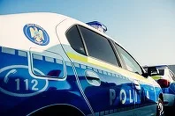Mașină de poliție parcată sub un cer senin, pregătită pentru evenimentele din Budapesta.
