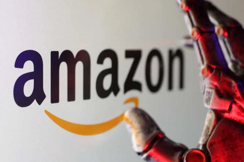 Logo-ul Amazon cu un braț robotic în prim-plan.