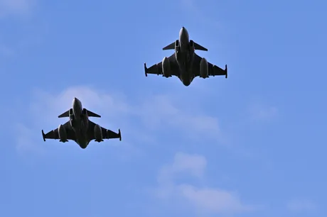Avioane de luptă Gripen zburând pe cerul albastru.