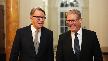 Keir Starmer și Peter Mandelson zâmbind într-un hol elegant.