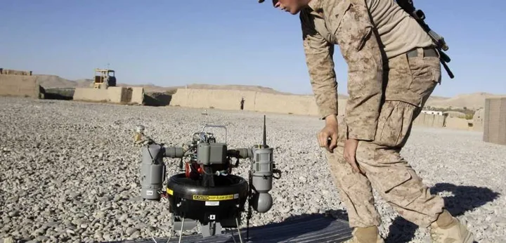 Soldat interacționând cu un sistem anti-dronă pe teren militar.