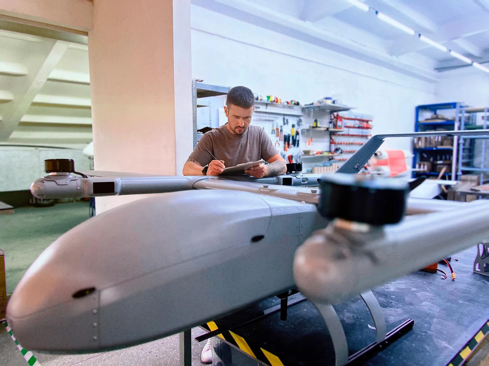 Un specialist lucrează la un sistem de drone într-un atelier tehnic.