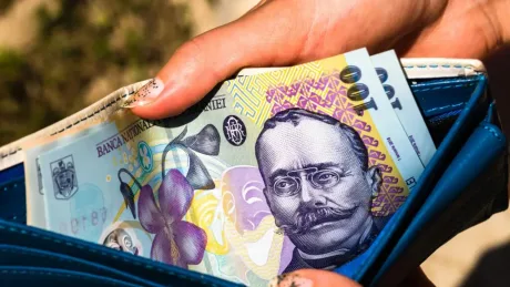 Bancnote românești ținute într-un portofel deschis, simbolizând economiile pentru pensii.