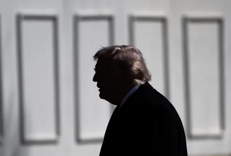 Silhouette a unei persoane în fața unui zid alb.