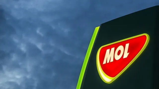 Logo-ul MOL iluminat pe fundal de cer înnorat.