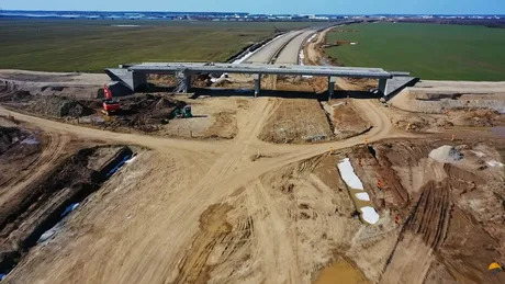 Lucrări în desfășurare pe autostrada A0, cu utilaje și teren pregătit.