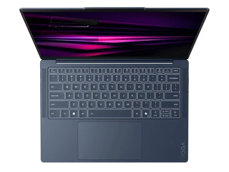 Laptopul Yoga Slim 7x cu ecran OLED deschis pe o masă.