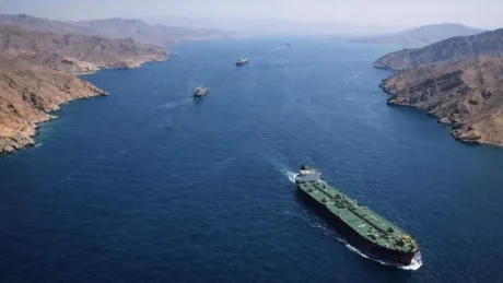Nave navigând în strâmtoarea Hormuz, pe fundalul peisajului montan din Oman.