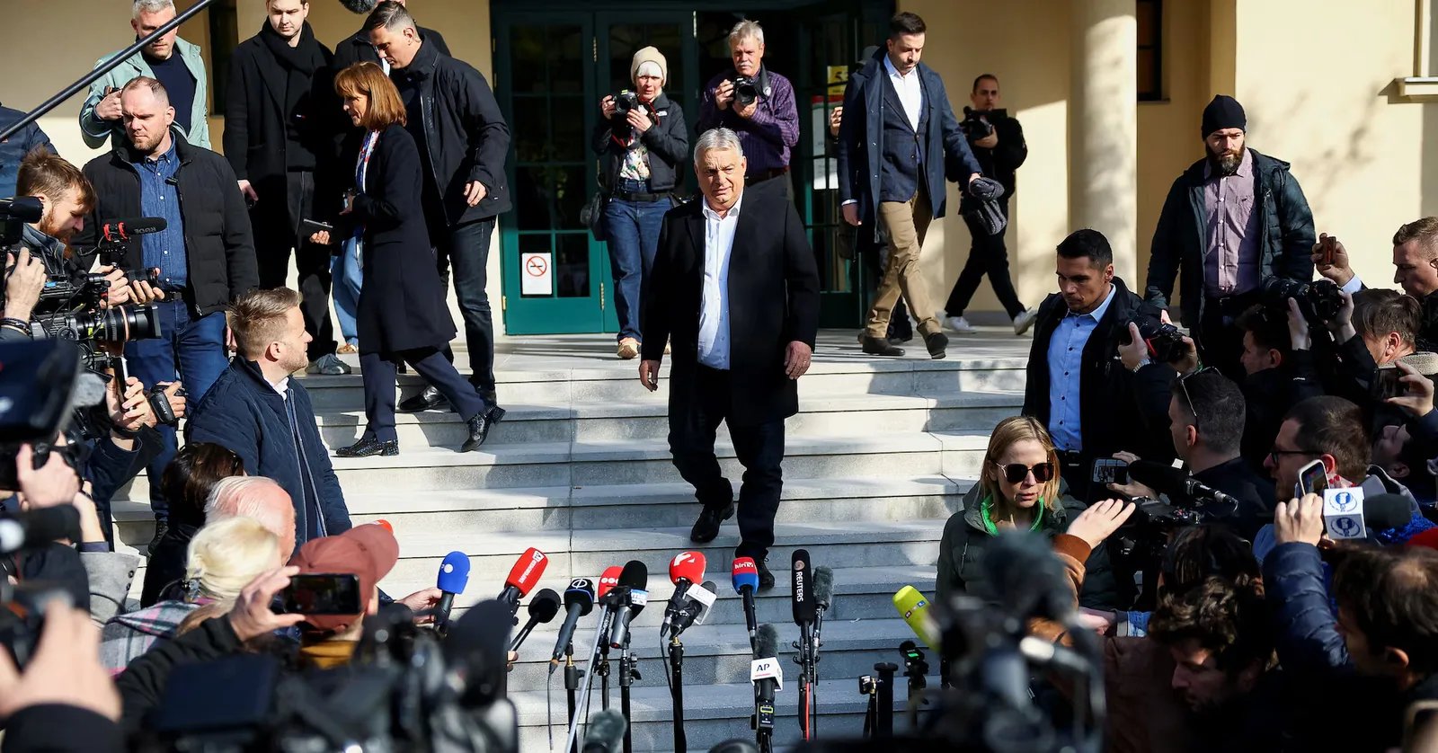 Viktor Orbán părăsește o clădire înconjurat de jurnaliști și camere de filmat.