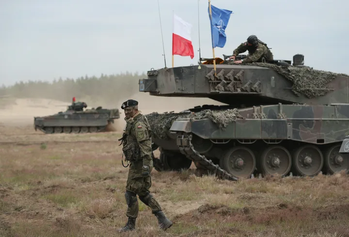 Soldați NATO desfășurând exerciții militare în Polonia, demonstrând mobilitate și cooperare.
