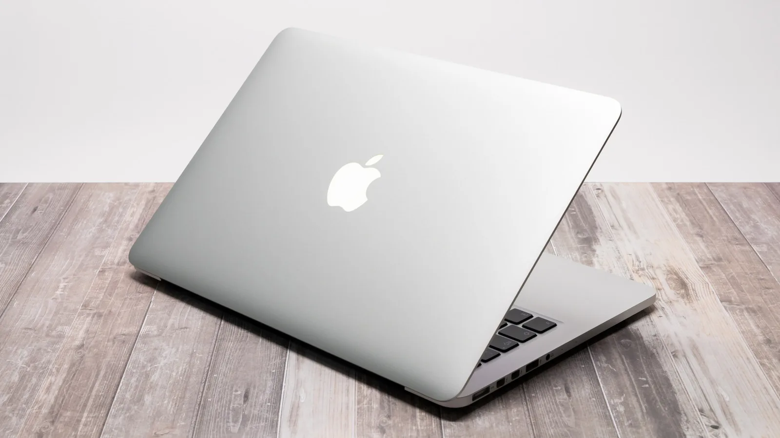 Laptop Apple deschis, cu un design elegant și simplu, fără logo iluminat.