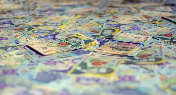 Bancnote românești aranjate pe o suprafață diversificată.