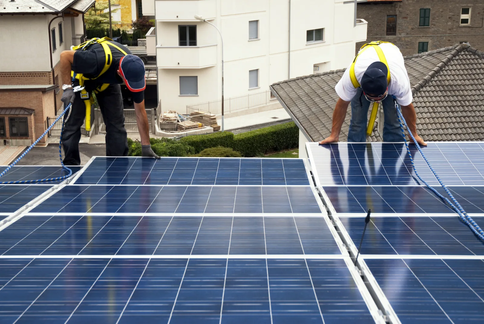 Prosumatori instalând panouri fotovoltaice pe acoperișuri în România.