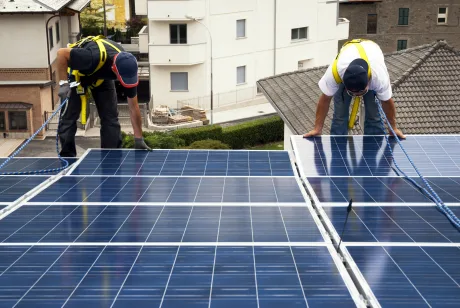 Prosumatori instalând panouri fotovoltaice pe acoperișuri în România.